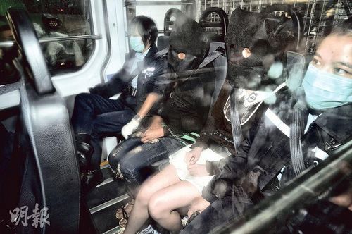 18岁女被告何菱瑜（右二）被控一项串谋谋杀罪，身穿啡色上衣、白色短裙，由警方押送至在荃湾裁判法院提堂。来源：香港《明报》