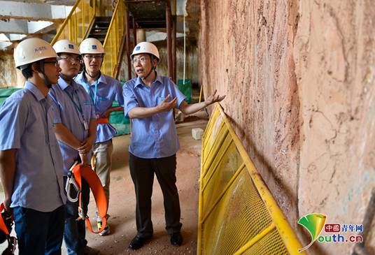 周予启（右一）为项目技术人员讲解基坑加固技术。本人供图