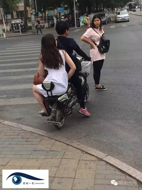 一名商贩骑电动车把两游客送进了校园