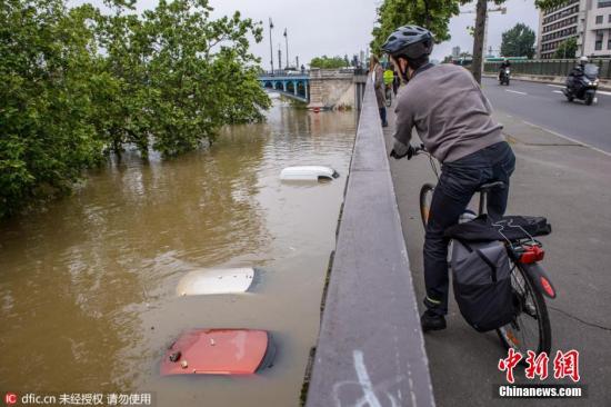 当地时间2016年6月2日，法国巴黎，强降雨天气导致塞纳河水位暴涨，河道航运被停止、临河道路和游乐设施被关闭。图为塞纳河边的一个停车场被完全淹没，车辆仅能露出顶部。 图片来源：东方IC 版权作品 请勿转载