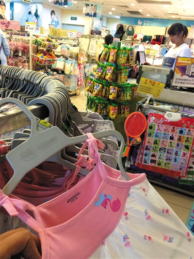 近日，国瑞购物中心内的一家母婴店里，一件粉红色的女童吊带连衣裙上设计有绳带。