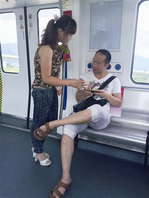 地铁车厢里，一姑娘邀请乘客扫描自己手机上的二维码 记者 叶萌茗 摄