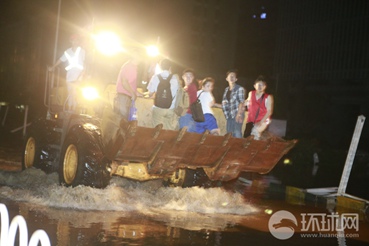7月6日夜里，在武汉光谷大道金融港，现场积水最深处可达1米，来往居民通过需要靠铲车摆渡通行。昊哥摄
