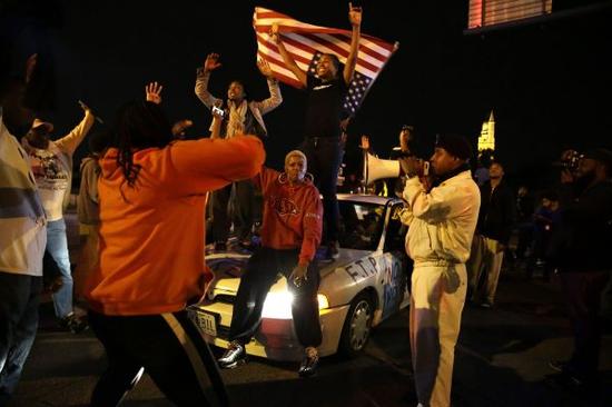 图说：这是2014年10月9日，抗议者在美国密苏里州圣路易斯市游行时高呼口号。10月8日，黑人青年冯德里特·迈尔斯在圣路易斯市遭一名不当班的白人警察枪杀。