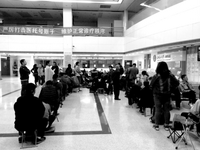 在医院大厅，挂号者排起长队。