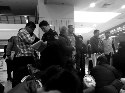 民警对排队挂号者进行登记。