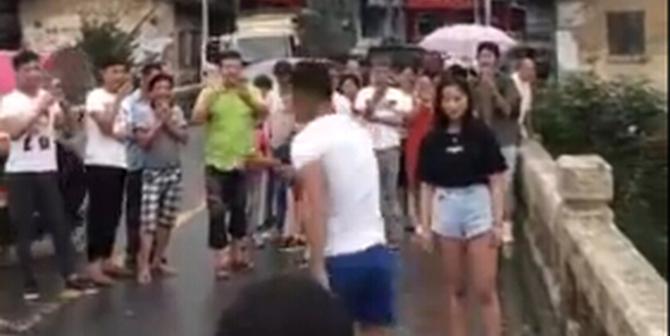 男子开始有些犹豫，但被女子的言语所激怒，手里的鲜花摔地上，准备跳河。