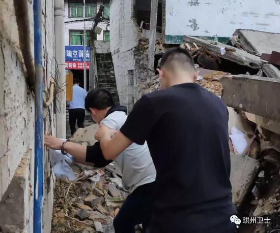 民警押送王某华指认现场（周女士的住房已经严重受损