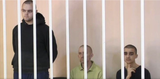 ↑近日，艾登·埃斯林（左）和肖恩·平纳（中）在顿涅茨克当地法庭受审
