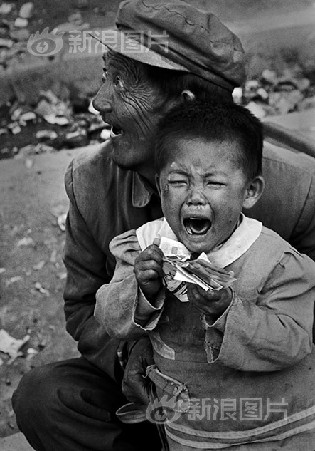 1992年9月，当上海市民正在为股票、期货而狂热的时候，远在西部的青海格尔木街头，彩票热才刚刚兴起。爷爷的彩票没有中奖，孙子哇哇大哭。满地的奖券，撕碎了多少梦想。摄影|于文国