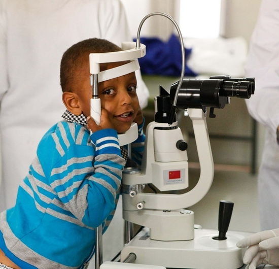↑ 2014年5月2日，在埃塞俄比亚首都亚的斯亚贝巴的阿勒特医院，一名小朋友等待参加“光明行”活动的中国眼科专家为他看诊。
