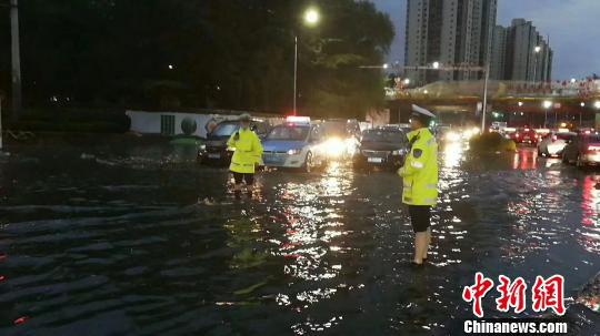 图为兰州交警在雨中疏导,确保道路安全。 钟欣 摄