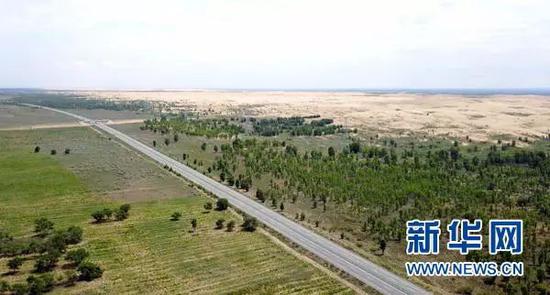 ▲汽车行驶在榆（林）靖（边）高速公路上（8月1日无人机拍摄）。穿越毛乌素沙漠的榆靖高速，是中国建成的第一条沙漠高速公路。