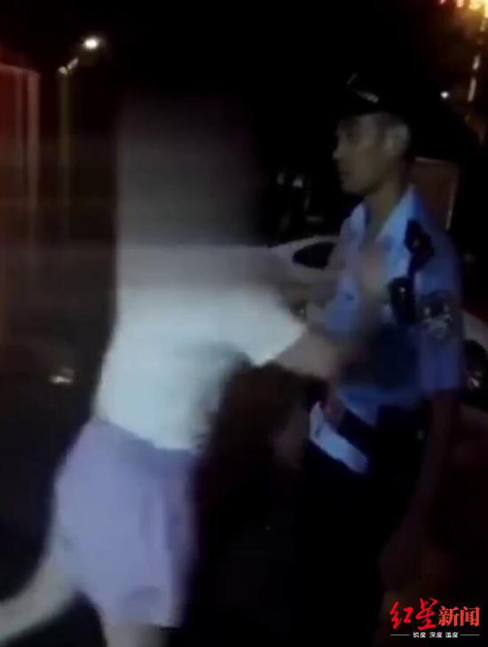 女子推搡民警。视频截图