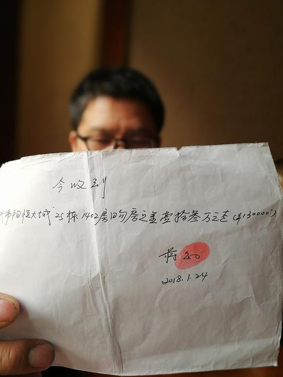 受害人武伟阳出示交了13万元购房定金的收条。 澎湃新闻记者 朱远祥 图       