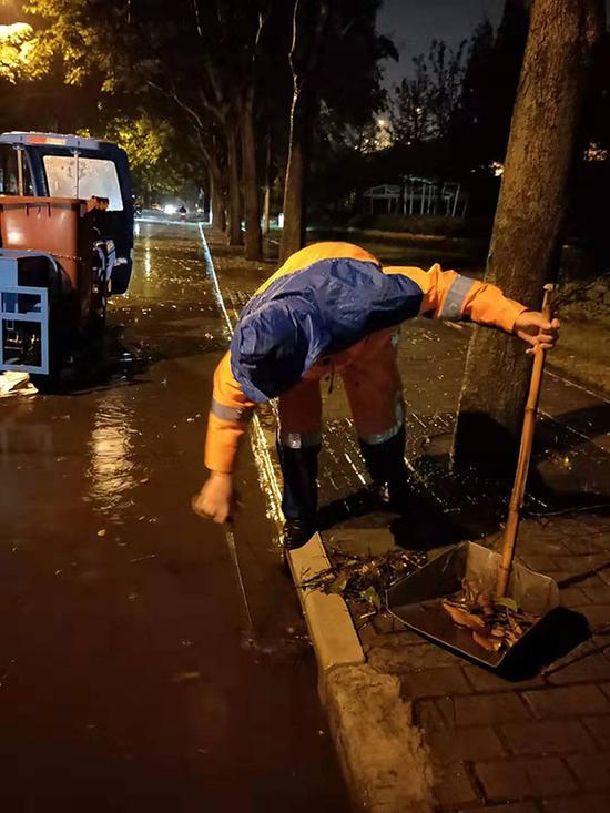 环卫工人清理积水路段。上海市绿化和市容管理局 图