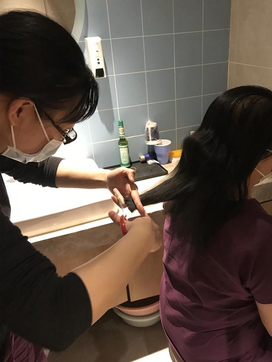进入病区前,刘津京为医疗队员们剪发。图/医院供图
