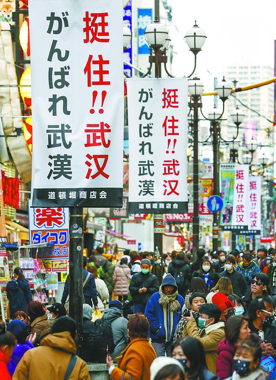 10日，日本大阪道頓堀商圈的街道上掛起中日雙語的“挺?。?！武 漢”標(biāo)語。近日，日本各界以不同形式為中國抗擊新冠疫情加油鼓勁。