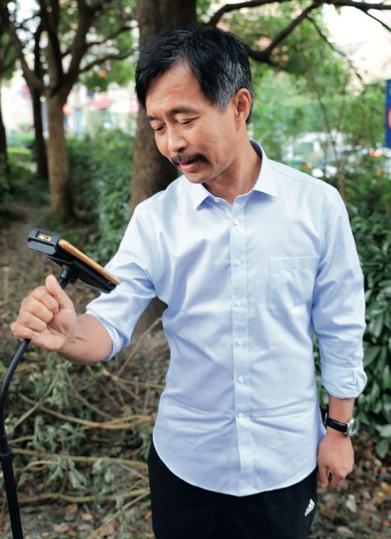 　　10月15日，换了一件蓝色的衬衣，沈巍再次来到他之前“成名”的流浪地：上海高科西路。摄影/本刊记者 董洁旭