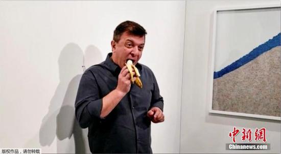当地时间12月7日，美国迈阿密海滩，意大利艺术家毛里·卡特兰标价12万美元的作品《喜剧演员》在巴塞尔艺术展上展出时，被行为艺术家达图那当场吃掉。
