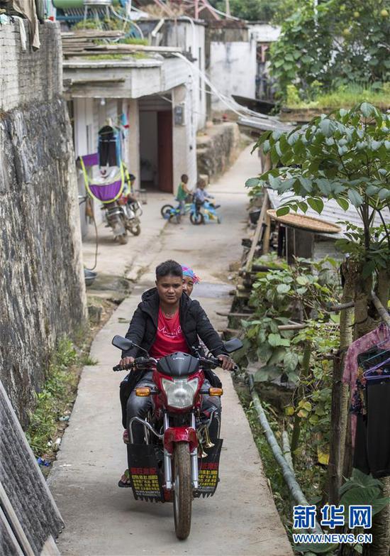 在云南省金平苗族瑶族傣族自治县者米乡地棚村小组，一名苦聪青年骑着摩托车出村（2018年11月13日摄）。新华社记者 胡超 摄