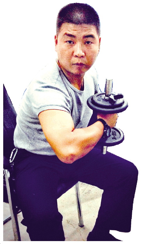 鲍志斌在办公室里“举铁”锻炼臂力。