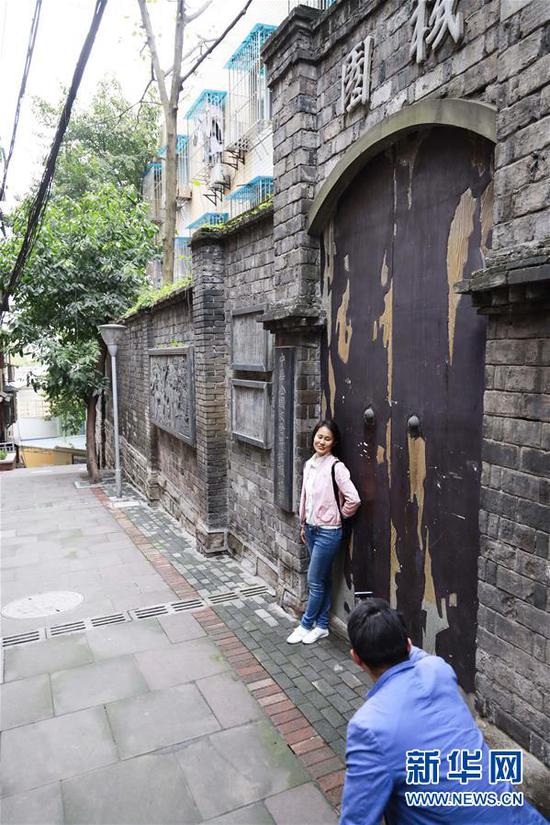 游客在重庆渝中区山城第三步道上的老建筑围墙外拍照留念（4月3日摄）。 新华社记者 刘潺 摄