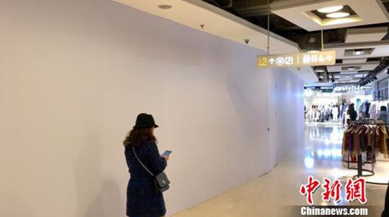 涉事店铺已闭店并用白色木质板材阻隔在表围进走了封闭式遮盖