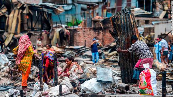 火灾后，贫民窟居民在寻找个人物品。图源：CNN