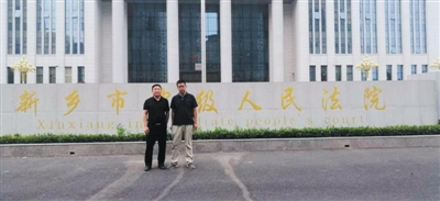 闫爱民（右）和律师付建在新乡市中级人民法院门口合影。受访者供图