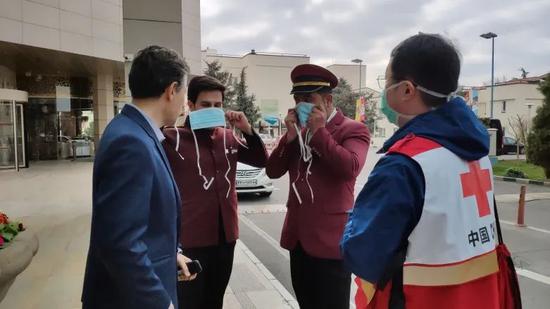 ▲伊朗酒店工作人员向中国专家请教口罩的佩戴方法