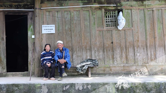 赵朋妈妈和大伯坐在家门前。华龙网-新重庆客户端记者 陈毅 摄