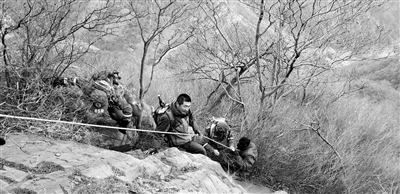 正月初六，登山驴友发现一名男子（右一）爬野山摔伤被困，救援人员合力送其下山