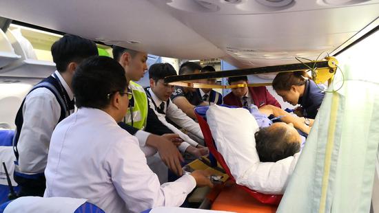 机组人员改装了6个座位,将旅客担架固定在航班上。 南航供图