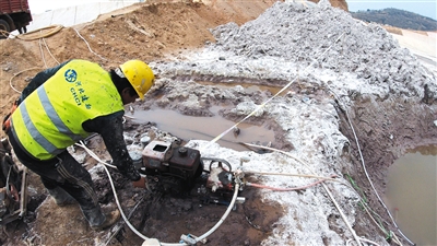 4月8日，原则沟赤泥库内，施工人员在进行抽水打钻作业。
