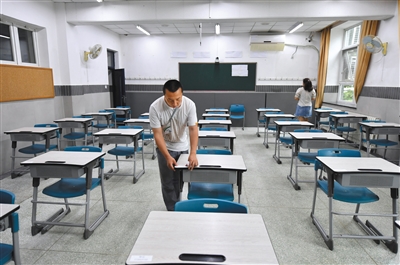 6月6日，北京一零一中学考点，监考老师在考场内贴桌签。