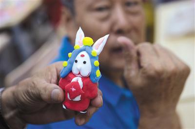 9月11日，牛街街道图书馆，居民在展示自己做的兔儿爷。新京报记者 王嘉宁 摄
