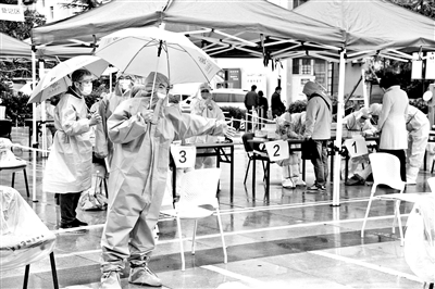 10月14日，工作人员在青岛市市北区海伦路街道一检测点引导市民进行核酸检测采样