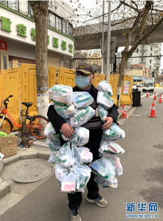 在武汉市江岸区黄石路汉口大药房，惠民苑社区网格员丰枫把为居民购买的药挂在身上（2月24日摄）。 新华社发