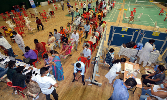 4月22日，居民在印度东北部城市高哈蒂的体育场排队接种新冠疫苗。