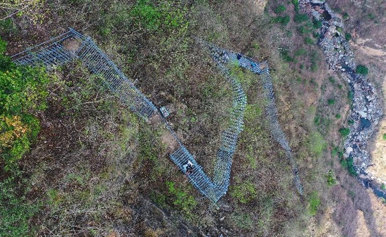 在四川省凉山彝族自治州昭觉县阿土列尔村的悬崖钢梯上，村民沿着钢梯下山（2020年5月13日摄）。新华社记者 王曦 摄