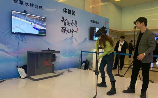 2019年12月26日,“5G赋能智慧冬奥”发布会今天在京召开。观众在体验智慧冰球训练。新京报记者 孙海光 摄