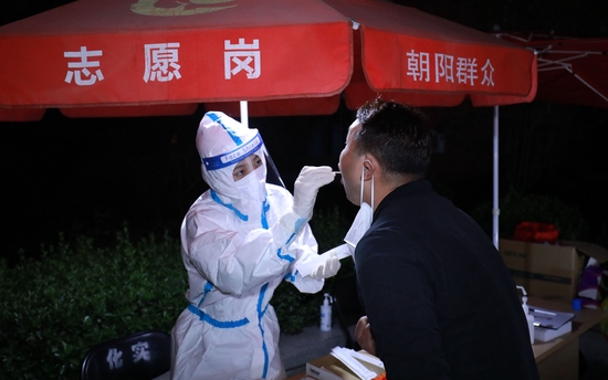 ▲医护人员正在为居民检测核酸。新京报资料图