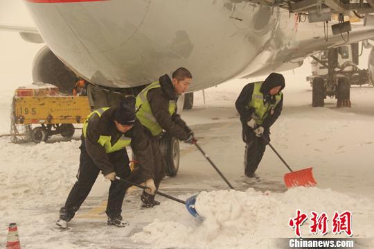 乌鲁木齐国际机场工作人员合力清雪。　郭一彤　摄