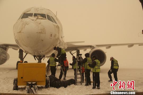 机场工作人员清雪中。　郭一彤 摄