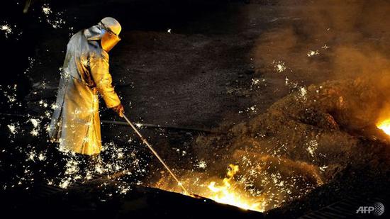 资料图片:一名美国钢铁厂工人在工作.(法新社)