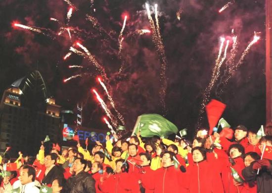 1999年12月19日晚,上海市各界人士汇聚黄浦江畔举行盛大的庆澳门回归联欢晚会。图为12月20日零点以后,礼花腾空,兴奋的人群热烈欢呼。新华社记者 凡军 摄