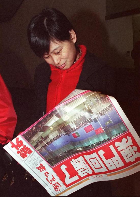 1999年12月20日凌晨1时许,《澳门日报》出了第一份回归报道号外,头版大标题“澳门回归了”赫然醒目。这是一位市民在阅读该报号外。新华社记者 刘建国 摄
