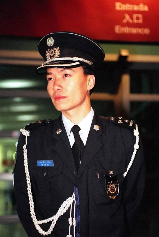 1999年12月20日是澳门回归祖国的第一天。从当天零时起,澳门警察全部佩戴上带有澳门特别行政区区徽图案的新警徽和新帽徽,取代了原先带有葡萄牙色彩的旧警徽。这是佩戴新警徽的警察在街头巡逻。新华社记者 鱼澜 摄