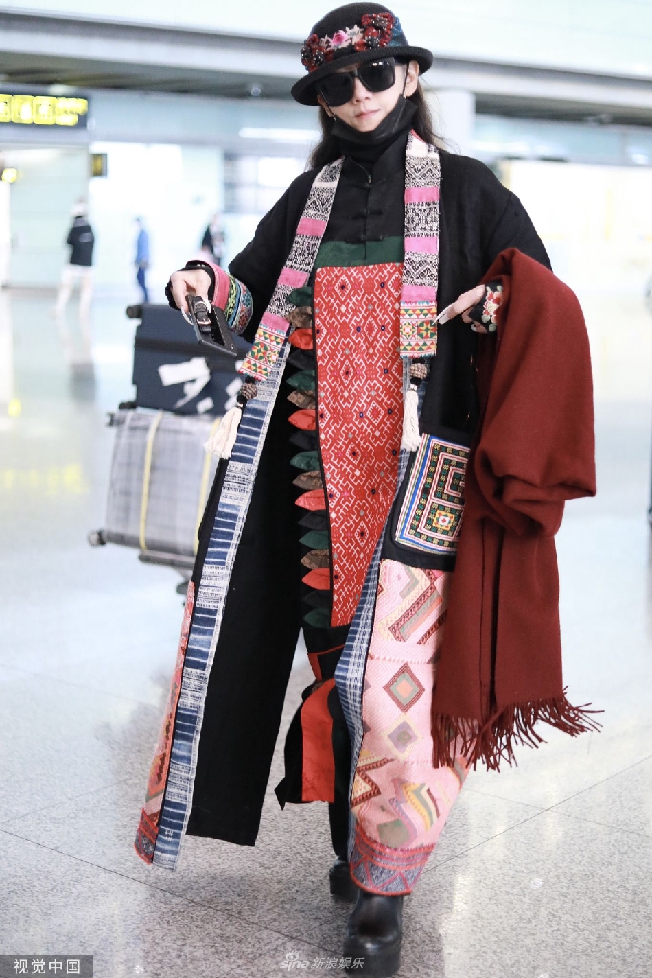 组图：杨丽萍红黑配色民族风造型抵达机场 冲镜头灿笑心情好